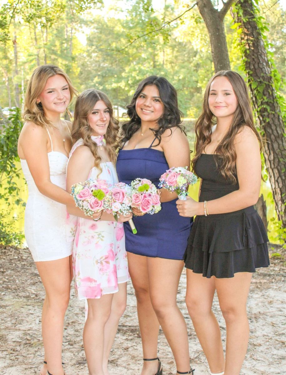 Four friends with bouquets before homecoming